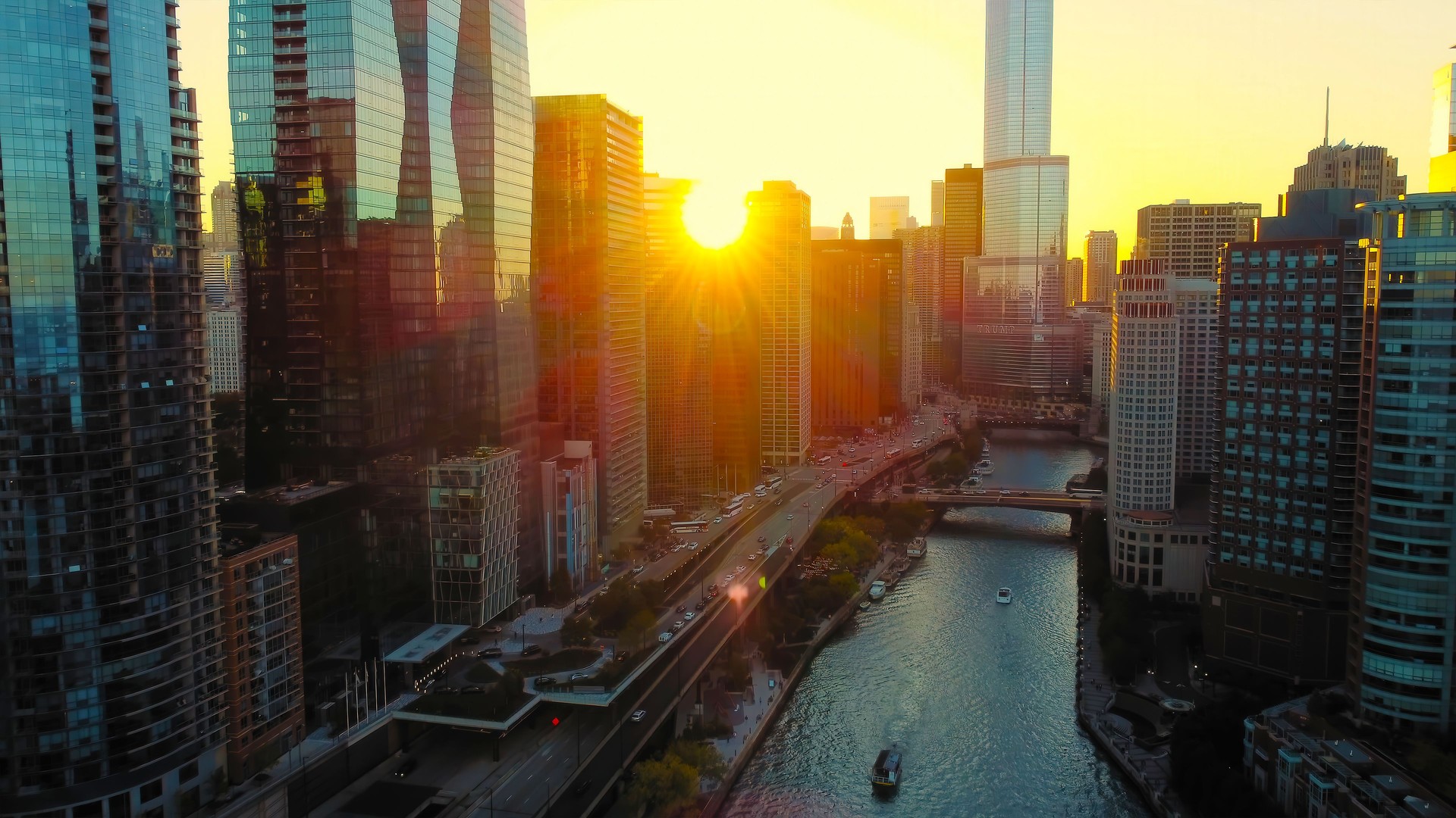 Chicago River and Skyscrapers at Sunset. Sunset view of Chicago's skyscrapers reflecting golden light along the Chicago River, creating a vibrant urban scene with boats and bridges.